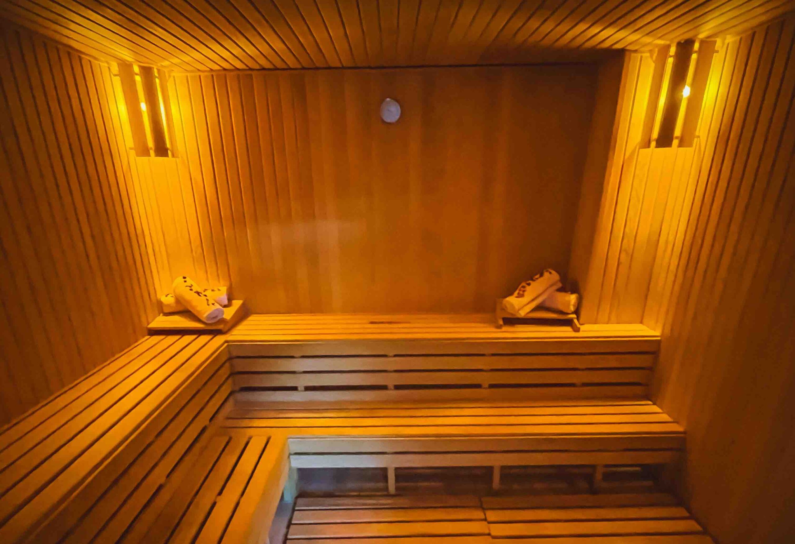 View of half the sauna room with a set of towels on each side of one long seat (Affordable Self-Care for Women in London)