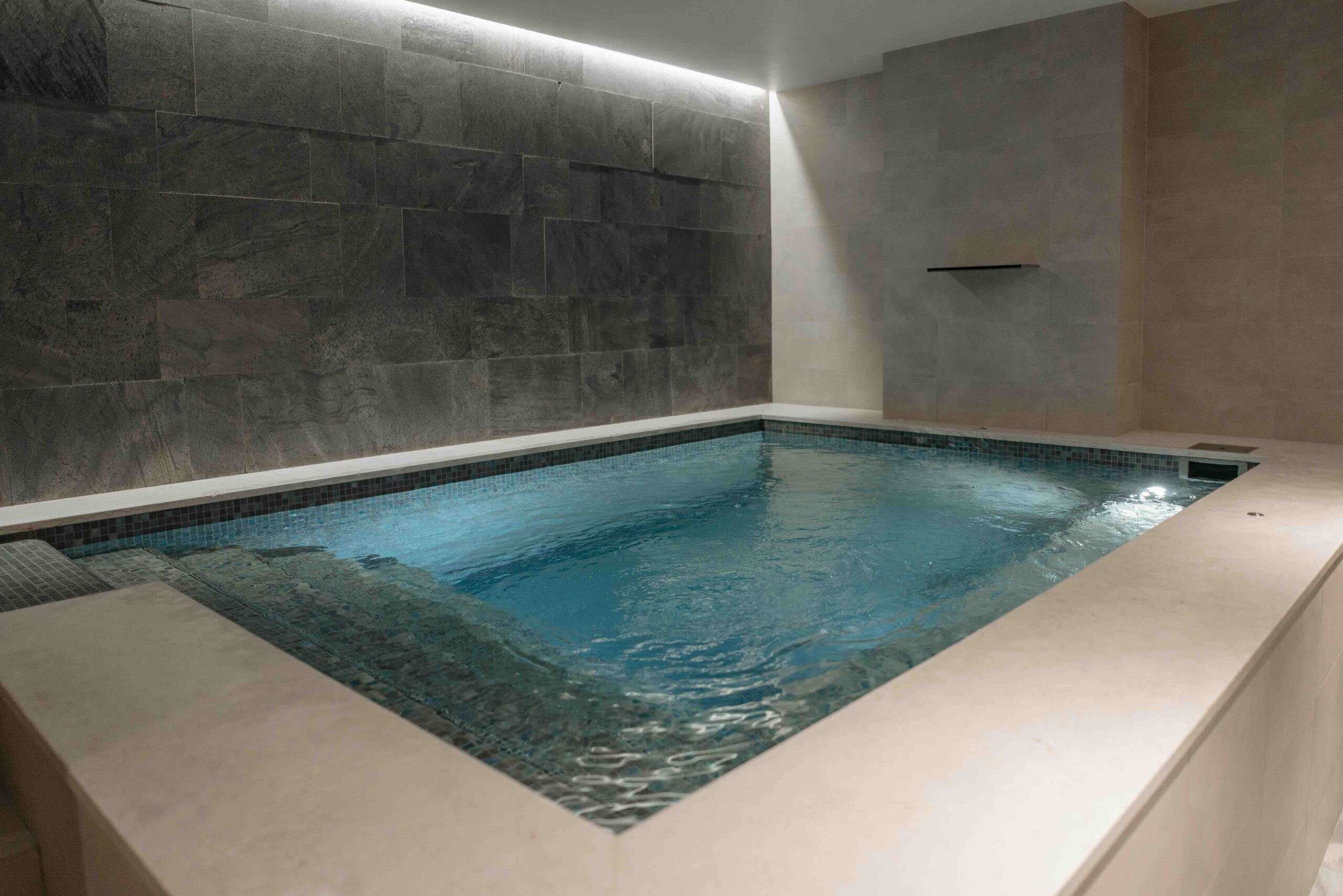 A small indoor pool that has four steps and tiling around it. (Budget-Friendly Wellness for Women in London)