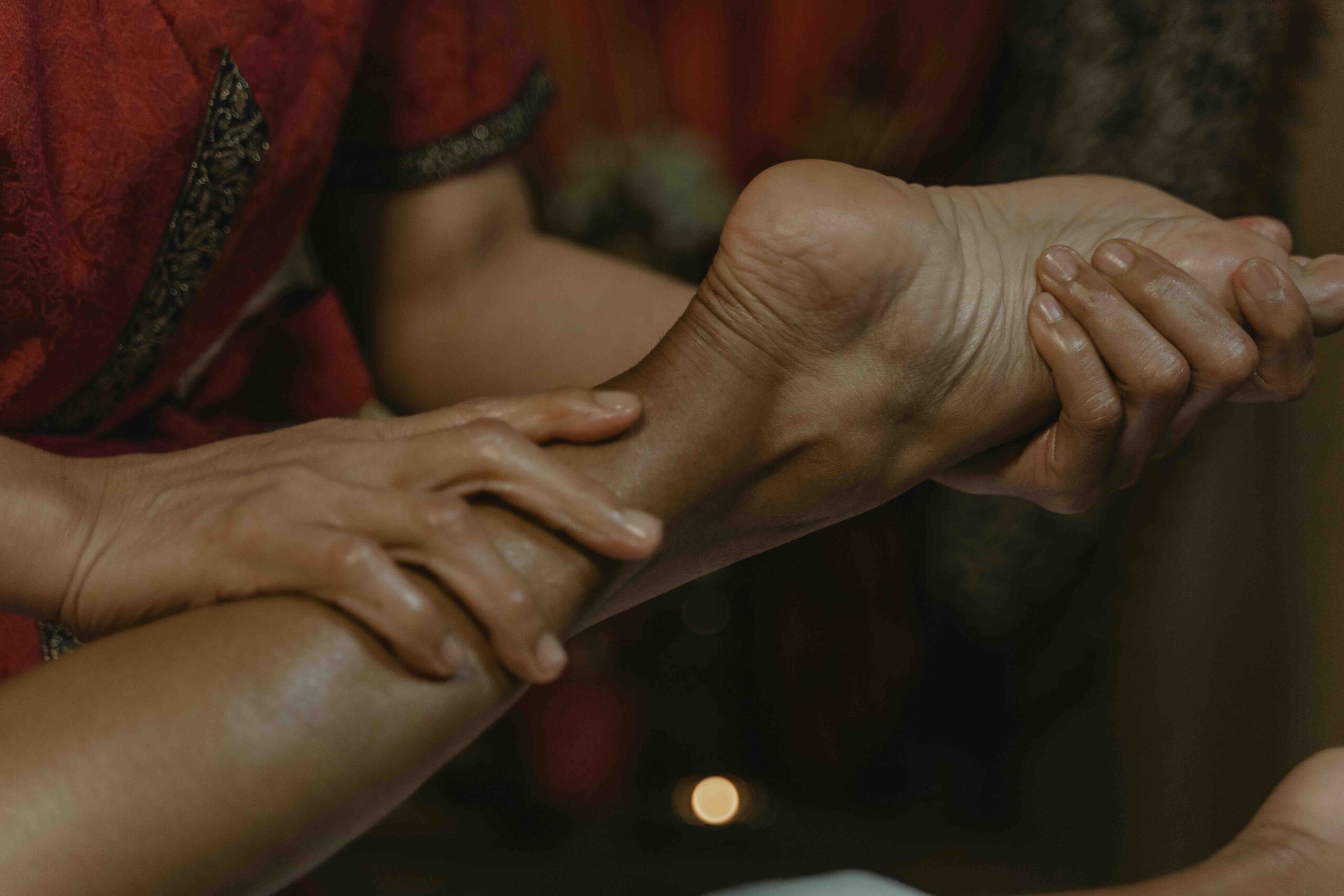 There is a lady who is holding part of a women's leg and foot to massage it (Cost-Effective Self-Care Options for Women in London)