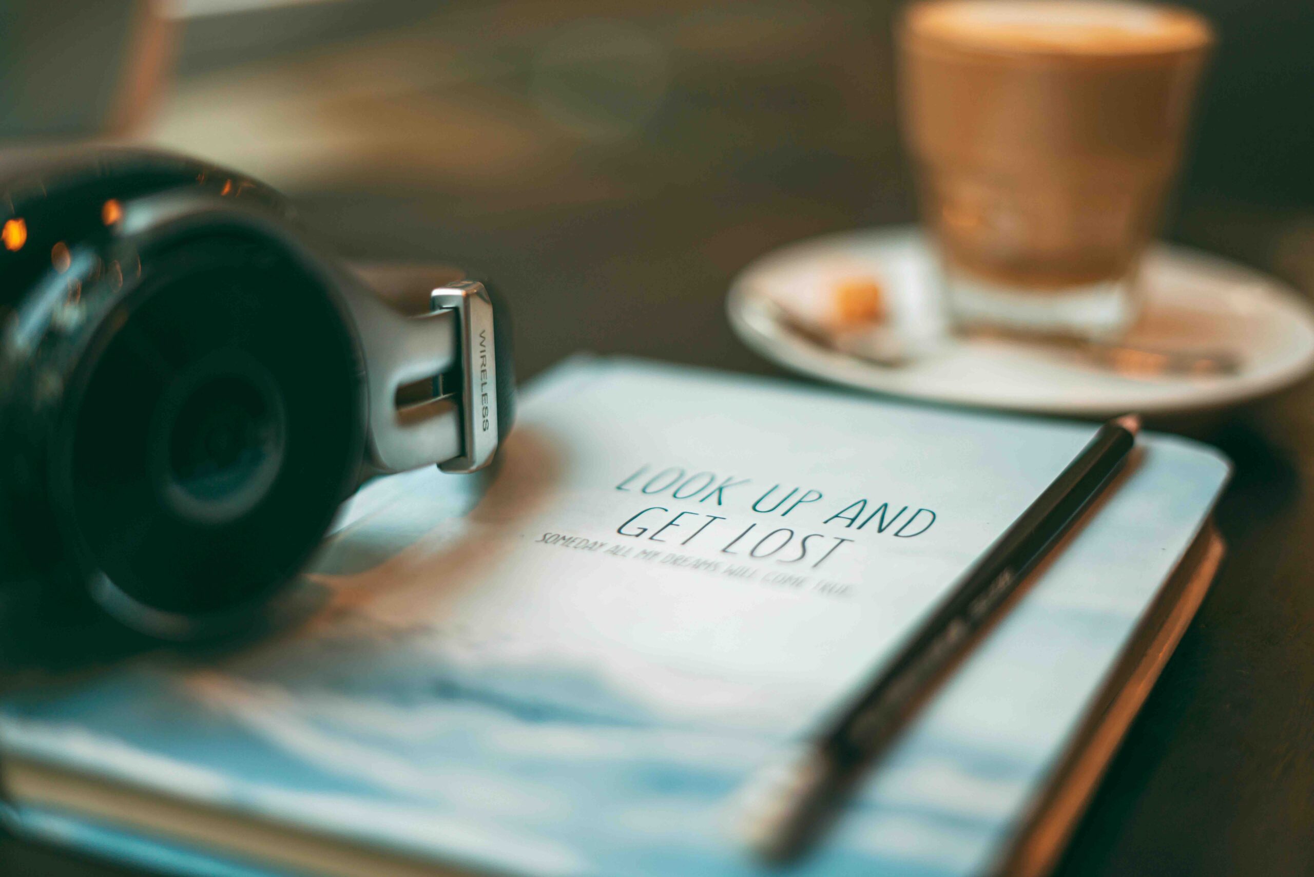 The image contains a book titles "Look up and get lost", a cup of coffee and a watch. (Accessible Self-Care for Women in London)